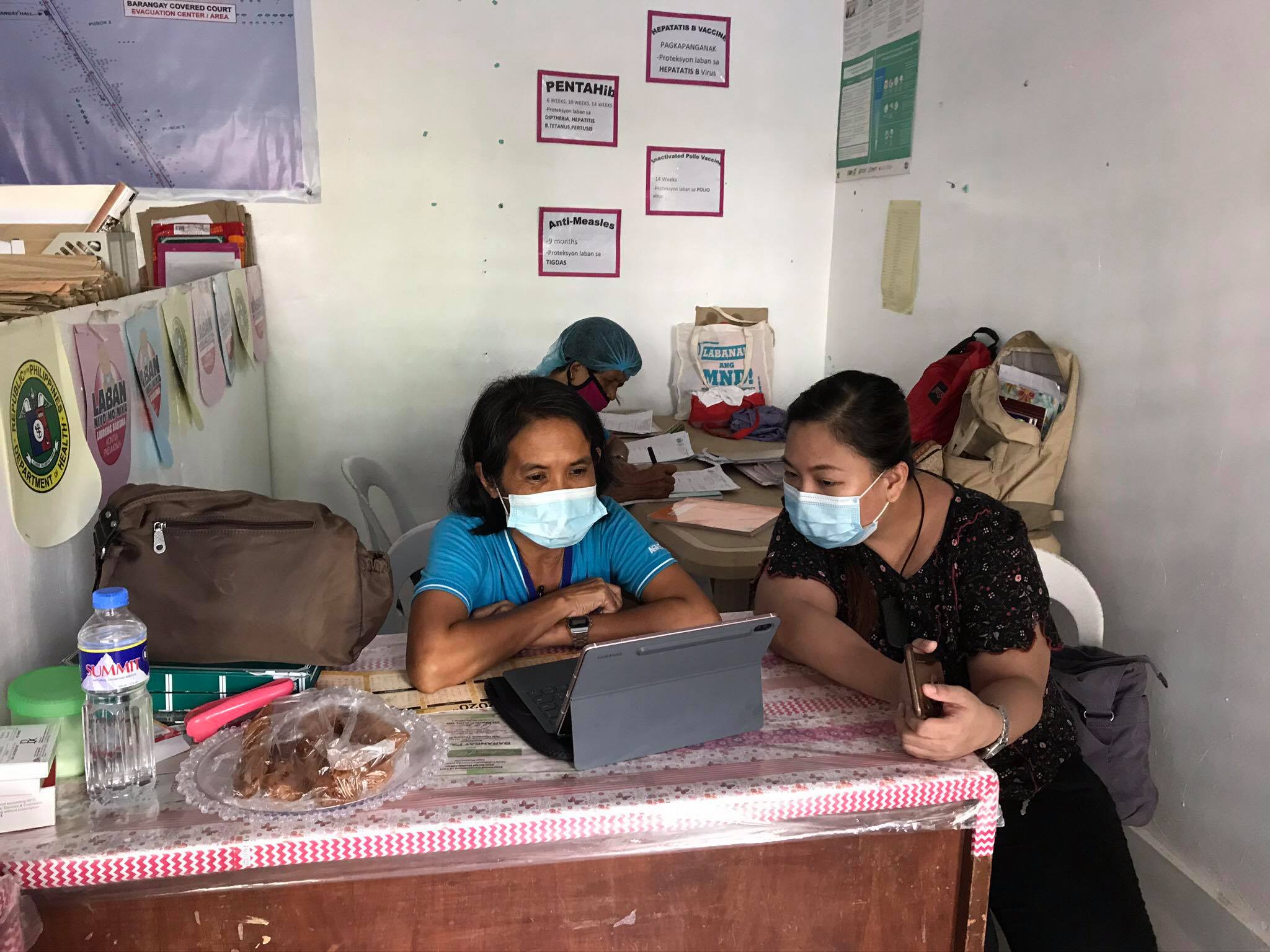 Dr. AM Gabuyo (one of our course faculty); sits with Ate Agnes, BHW of Bgy. Talon. Amadeo to take her through the BHERTs Training Needs Assessment questionnaire being remotely administered by a medical intern last June 2020.